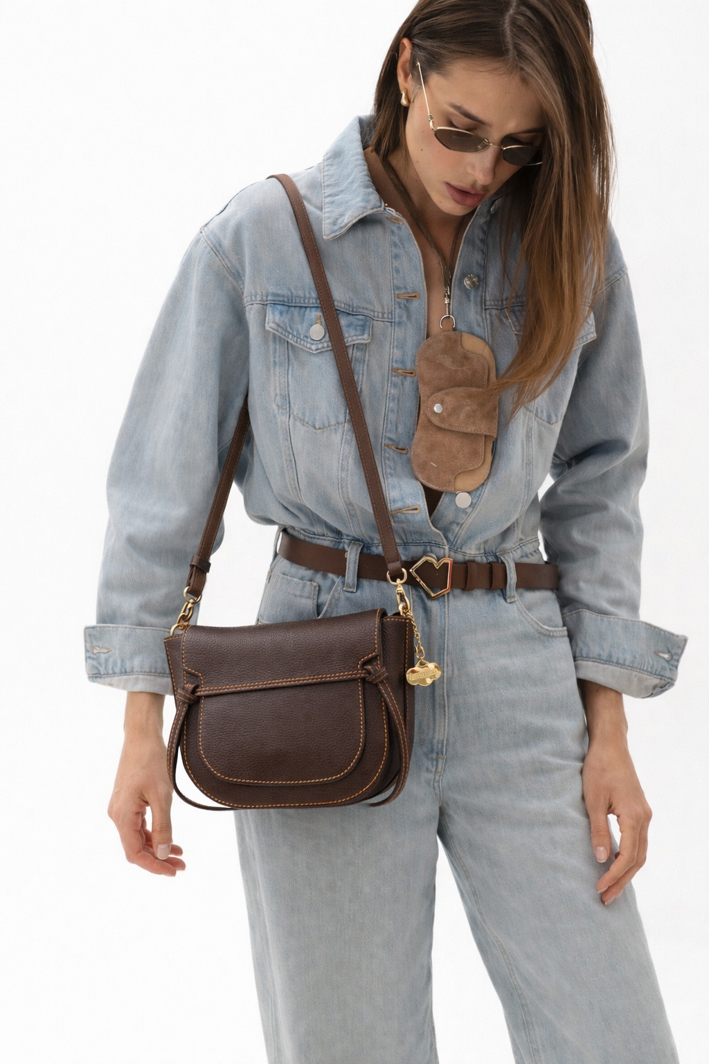 Bolso bandolera de piel chocolate con solapa y costuras en contraste, estilo ecuestre y diseño artesanal elegante