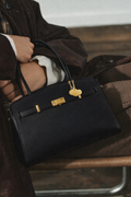 Bolso Diábolo Lux Midi negro en piel de vacuno con herrajes dorados y diseño estructurado.