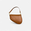 Bolso silla de montar de piel camel con doble correa y compartimento con cremallera, interior forrado y guardapolvos.