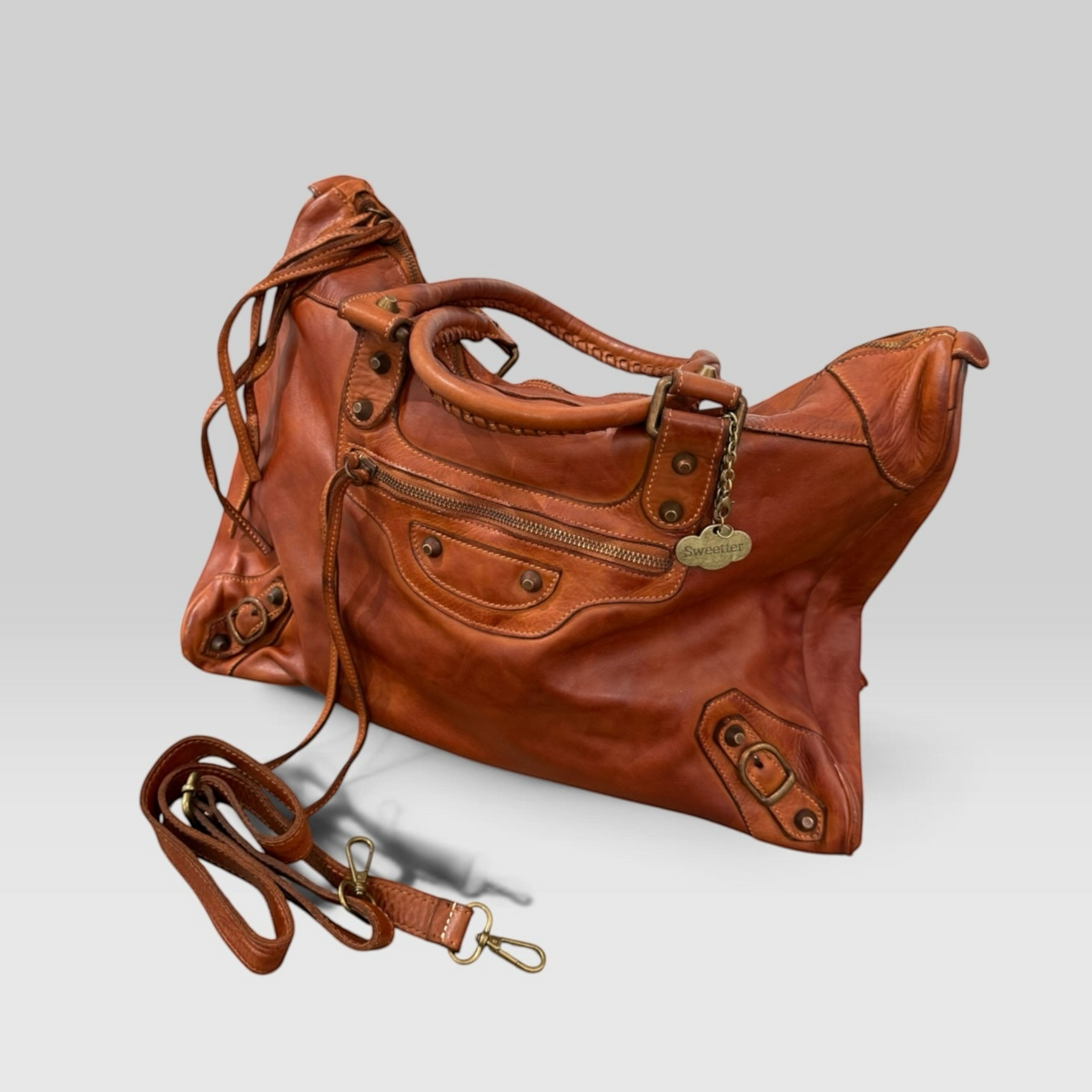 Bolso de mano Sweetterstore de piel italiana color cuero con asas trenzadas, herrajes vintage y correa ajustable.