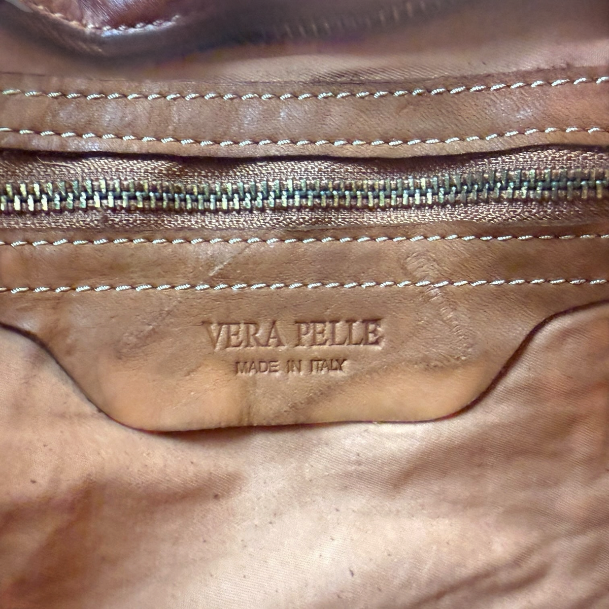 Detalle interior del bolso Sweetterstore con etiqueta grabada Vera Pelle Made in Italy y cierre de cremallera metálico