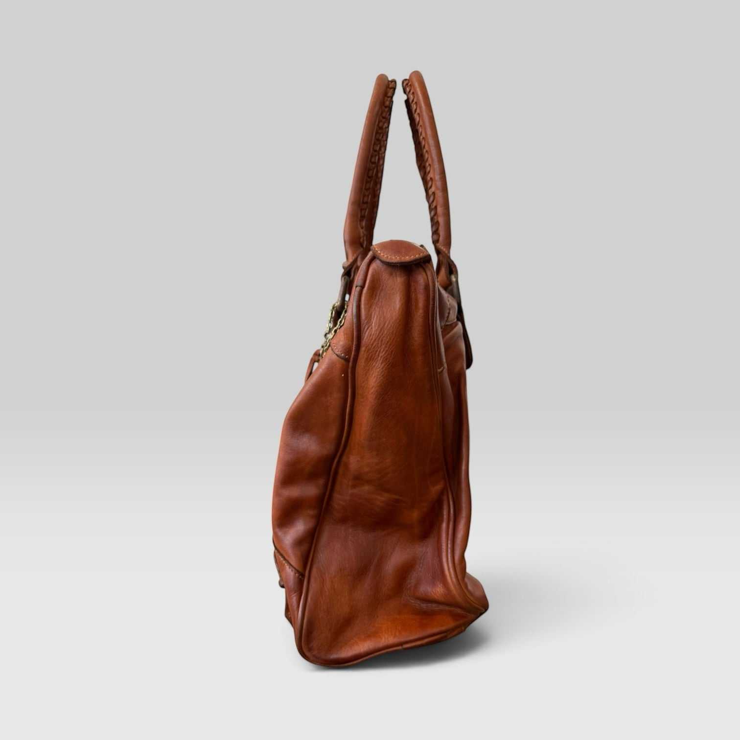 Bolso de mano Sweetterstore de piel italiana color cuero con asas trenzadas y diseño artesanal visto de perfil